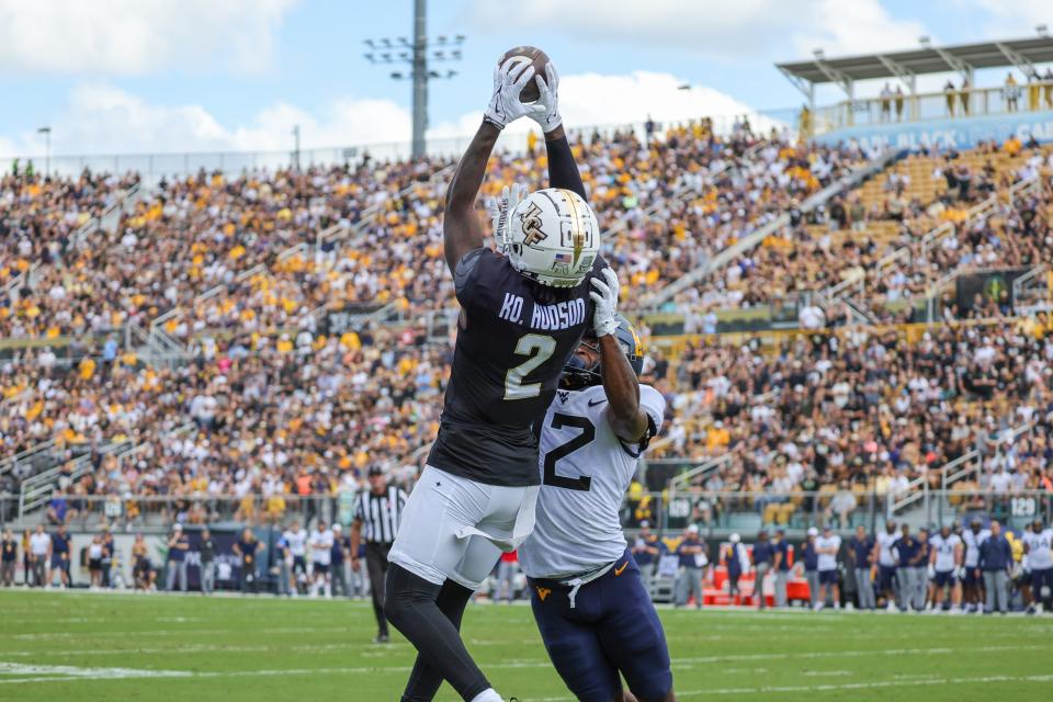 UCF wide receiver Kobe Hudson catches a touchdown pass in front of West Virginia safety Anthony Wilson during the first quarter at FBC Mortgage Stadium in Orlando, Florida on Oct. 28, 2023.