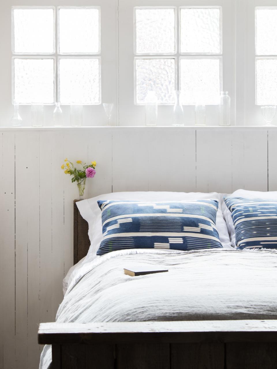 Decorative glassware lines the nearby shelf, which could be scooched to the side to make room for a book and reading glasses.