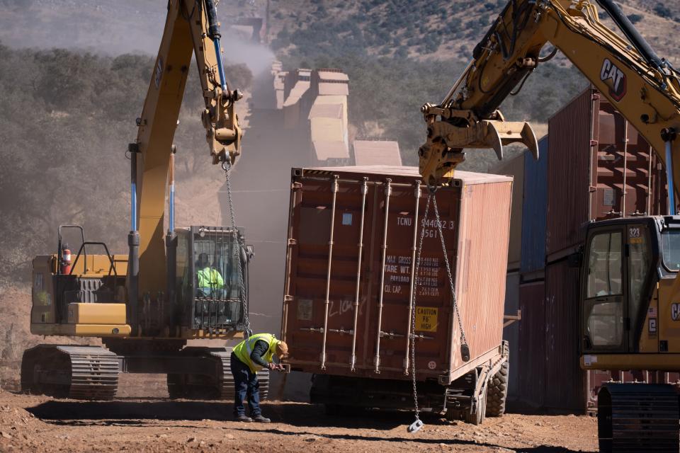 A shipping container is readied to be hoisted into place at the U.S./Mexico border on Nov. 18, 2022, southwest of Sierra Vista, Arizona.