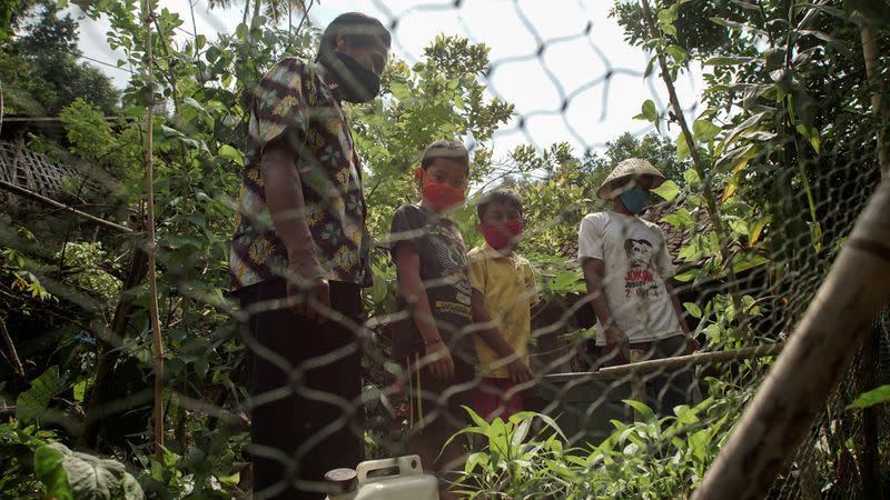 Henrikus Suroto, 57, wears a batik shirt and a protective face mask during a face-to-face lesson, in Magelang