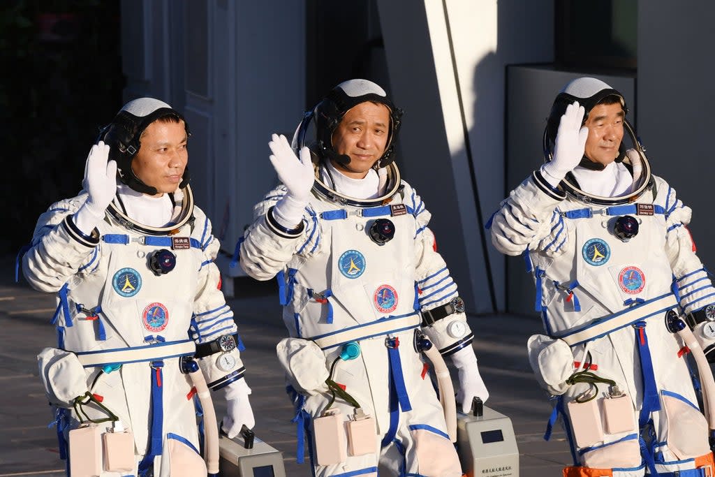 Astronauts Nie Haisheng (C), Liu Boming (R) and Tang Hongbo salute during a departure ceremony  (AFP via Getty Images)