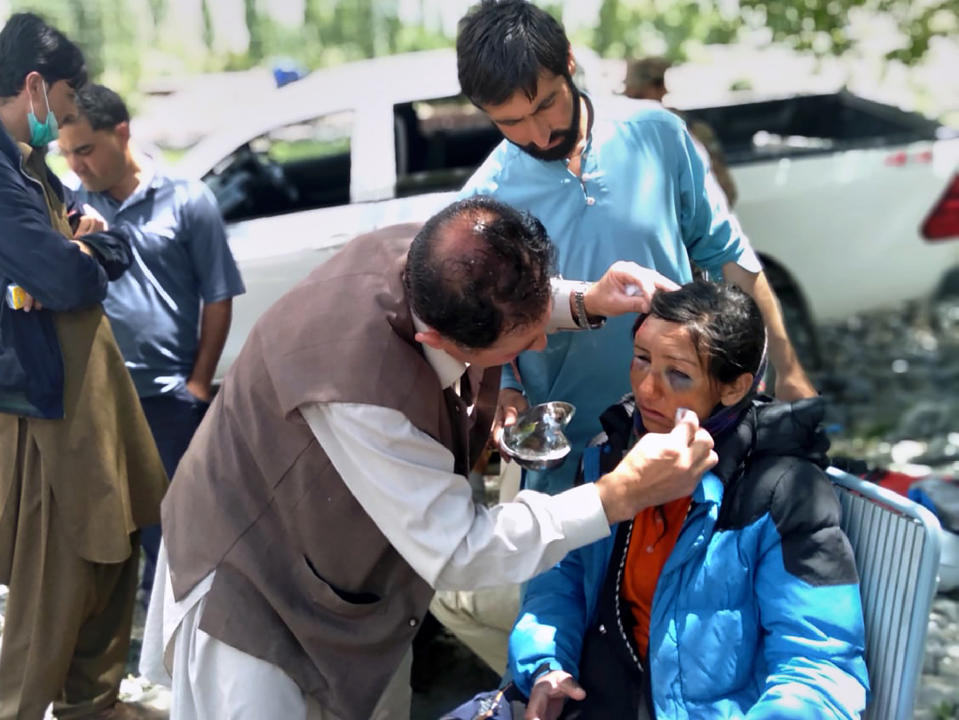 In this photo provided by Gilgit Baltistan regional police department, mountaineers receive initial treatment following her rescue, at a helipad in the town of Imit, Ghizer district of Gilgit Balistan region, Pakistan, Tuesday, Jun 18, 2019. A Pakistani army helicopter rescued on Tuesday four Italian and two Pakistani climbers stranded at an altitude of around 5,300 meters (17,390 feet) in the country's north, after an avalanche struck the team the previous day, a mountaineering worker said. A Pakistani member of the team was killed. (Gilgit Baltistan regional police department via AP)