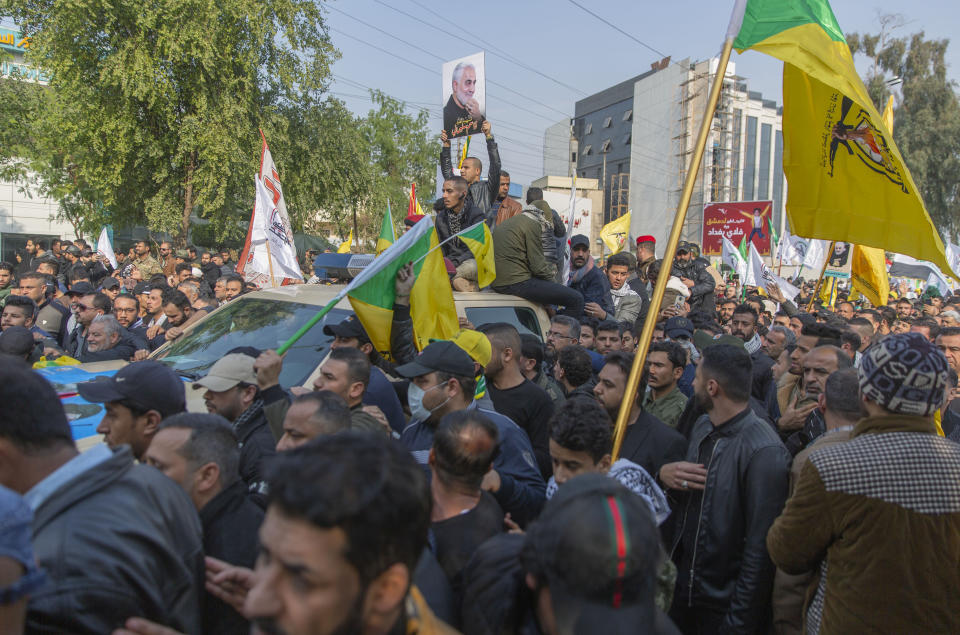 Mourners march during the funeral of Iran's top general Qassem Soleimani, 62, Abu Mahdi al-Muhandis, deputy commander of Iran-backed militias in Iraq known as the Popular Mobilization Forces and fellow militant leaders, in Baghdad, Iraq, Saturday, Jan. 4, 2020. Thousands of mourners chanting "America is the Great Satan" marched in a funeral procession Saturday through Baghdad for Iran's top general and Iraqi militant leaders, who were killed in a U.S. airstrike. (AP Photo/Nasser Nasser)