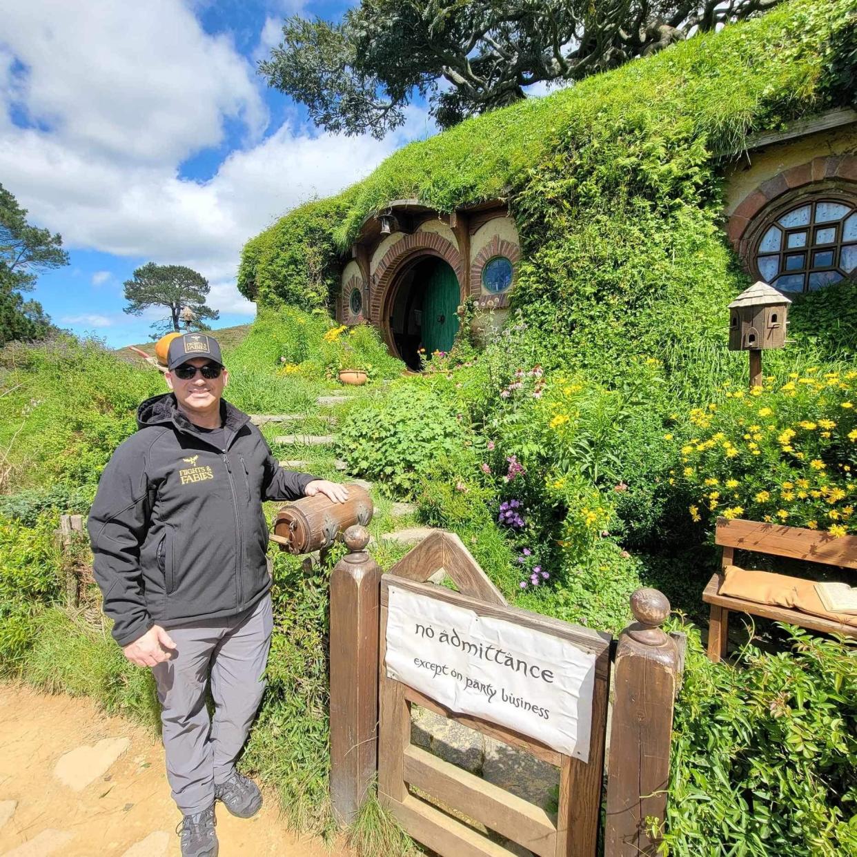 Rocky Dimico, owner of Fayetteville-based fantasy-travel agency Flights & Fables, poses at the Hobbiton Movie Set in New Zealand, the village from the Lord of the Rings and the Hobbit movies. Dimico curates travel itineraries for fantasy enthusiasts with his travel agency.