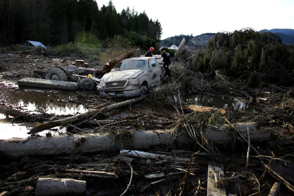 Search and rescue personnel continue working the area of Saturday's mudslide, Monday, March 24, 2014, near Oso, Wash. The search for survivors of the deadly mudslide grew Monday to include scores of people who were still unaccounted for as the death toll from the wall of trees, rocks and debris that swept through a rural community rose to at least 14. (AP Photo/seattlepi.com, Joshua Trujillo)