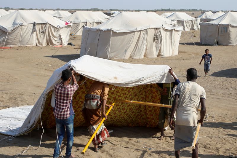 People erect a tent at al-Wara camp for internally displaced people in al-Khukha of Hodeidah province