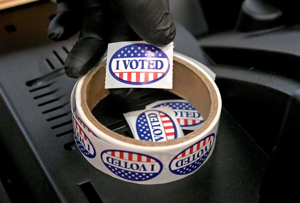 During the 2022 https://presto.gannettdigital.com/midterm elections, an "I voted" sticker is held by a polling place worker, on Nov. 8, 2022, at the Fourth Ward, 1st Precinct polling place at the Bayfront NATO/Martin Luther King community center, 312 Chestnut St. in Erie.