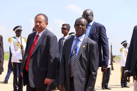 Sudan's prime minister Abdalla Hamdok walks next to South Sudan's vice-president James Wani Igga as he arrives for meetings with Sudan's ruling council and rebel leaders for a roadmap for peace talks, at the Juba international airport in Juba