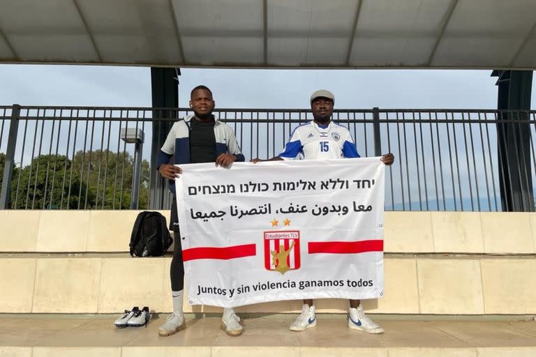 Dos de los integrantes del plantel de Estudiantes de Tel Aviv y un mensaje que simboliza la idiosincrasia del equipo.