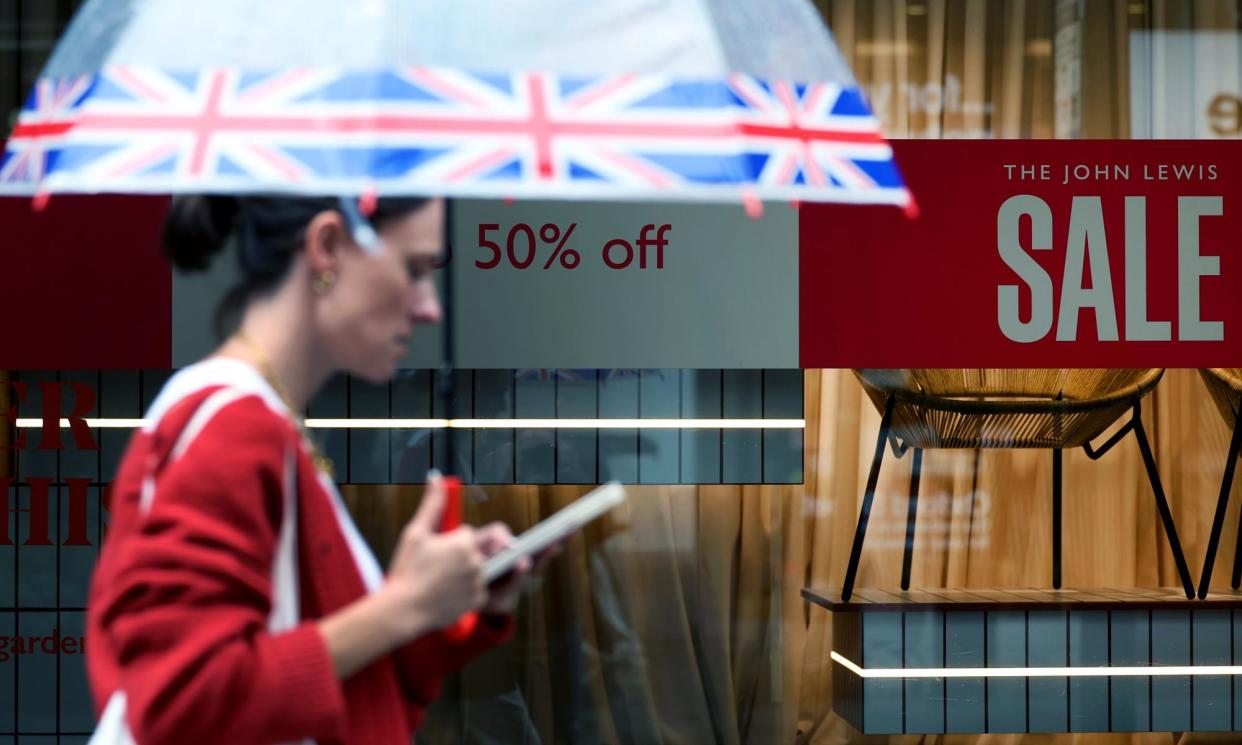 <span>A shopper on Oxford Street in London. The wet summer has been a washout for fashion retailers.</span><span>Photograph: Andy Rain/EPA</span>