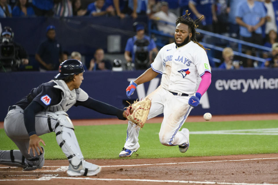 Toronto Blue Jays' Vladimir Guerrero Jr. slides, but will be tagged out by Cleveland Guardians catcher Bo Naylor (23) during the fourth inning of a baseball game Friday, Aug. 25, 2023, in Toronto. (Christopher Katsarov/The Canadian Press via AP)
