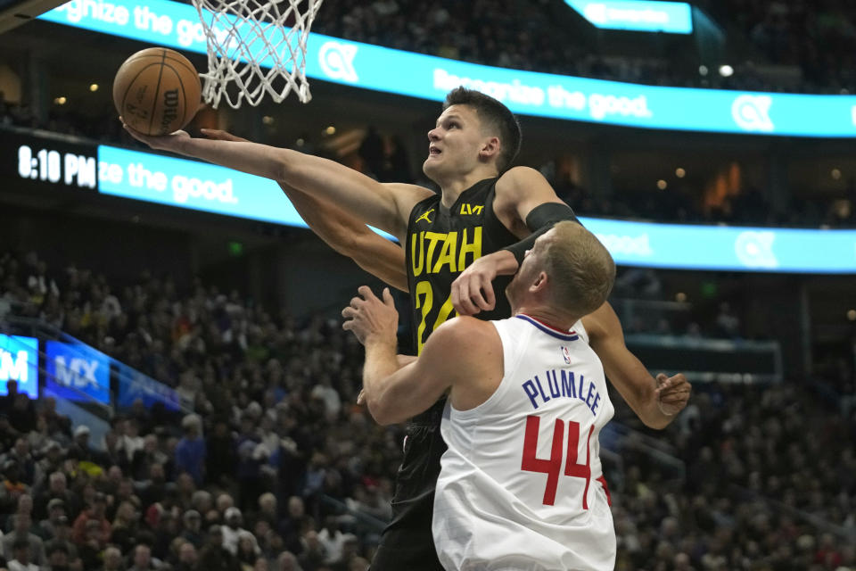 Utah Jazz center Walker Kessler, top, goes to the basket as Los Angeles Clippers center Mason Plumlee (44) defends during the first half of an NBA basketball game Friday, Oct. 27, 2023, in Salt Lake City. (AP Photo/Rick Bowmer)