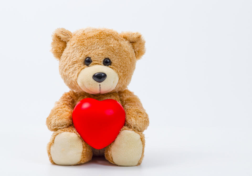 Stuffed bear holding a plastic heart