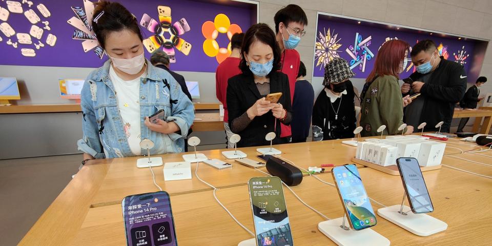 People hold iPhone14 mobile phones at an Apple store in Shanghai, China.