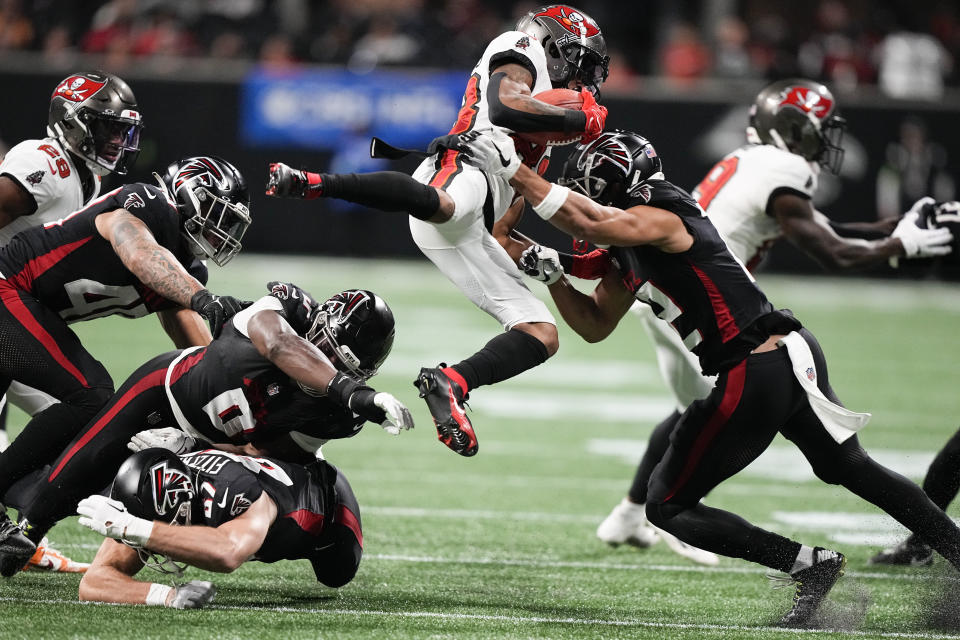 Tampa Bay Buccaneers wide receiver Deven Thompkins (83) is stopped by Atlanta Falcons wide receiver KhaDarel Hodge (12) during the second half of an NFL football game, Sunday, Dec. 10, 2023, in Atlanta. (AP Photo/Brynn Anderson)