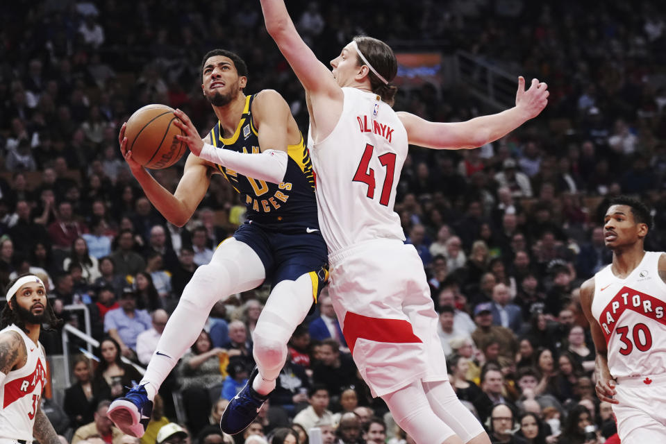 Indiana Pacers guard Tyrese Haliburton (0) drives to the basekt as Toronto Raptors forward Kelly Olynyk (41) defends during the first half of an NBA basketball game in Toronto on Tuesday, April 9, 2024. (Nathan Denette/The Canadian Press via AP)