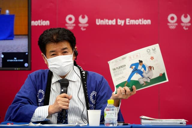 Tokyo 2020 Games delivery officer Hidemasa Nakamura holding a copy of the playbook during a media briefing on Wednesday