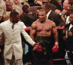 <p>Mike Tyson, center, reacts to the crowd as he leaves the ring following his bout with WBA heavyweight champion Evander Holyfield, Saturday night, June 28, 1997, at the MGM Grand Garden in Las Vegas. Tyson was disqualified after biting Holyfield’s ear twice in the third round. (AP Photo/Lennox McLendon) </p>