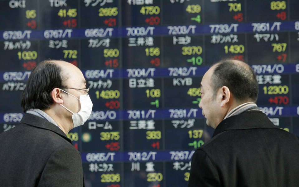 People walk by an electronic stock board of a securities firm in Tokyo,Thursday, Feb. 23, 2012. Asian stock markets were mostly lower Thursday as investors fretted over the details of a deal to save Greece from financial collapse and preserve its place among nations that use the euro. Japan bucked the trend as the yen weakened, boosting exporter shares. Japan's 225 Nikkei added nearly 0.1 percent to 9,562.51 as the dollar traded near a seven-month high against the yen. (AP Photo/Koji Sasahara)