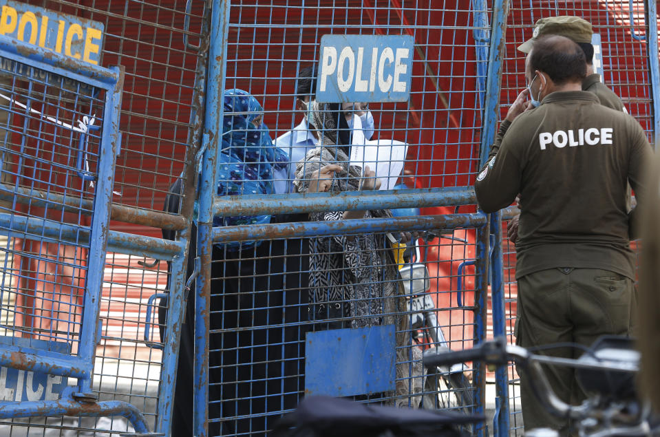 Residents of coronavirus infected area argue with police officers who sealed the area in Lahore, Pakistan, Wednesday, June 17, 2020. Pakistan ranks among countries hardest hit by the coronavirus with infections soaring beyond 18,000, while the government, which has opened up the country hoping to salvage a near collapsed economy, warns a stunning 1.2 million Pakistanis could be infected by the end of August. (AP Photo/K.M. Chaudhry)