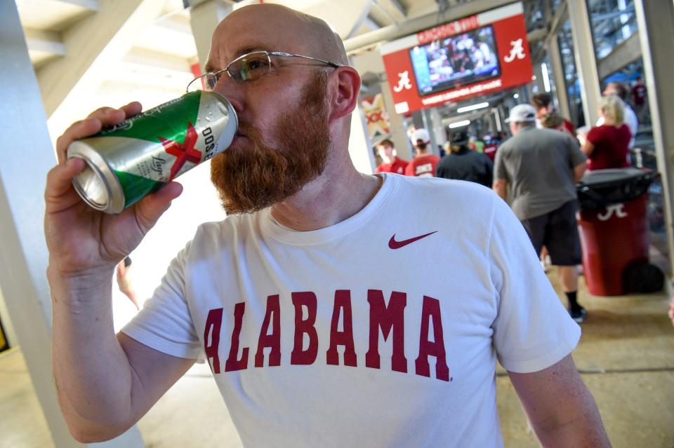 Sep 3, 2022; Tuscaloosa, Alabama, USA;  Heath Moore takes a drink of a beer at Bryant-Denny Stadium on the first day of legal sales inside the stadium. Mandatory Credit: Gary Cosby Jr.-USA TODAY Sports