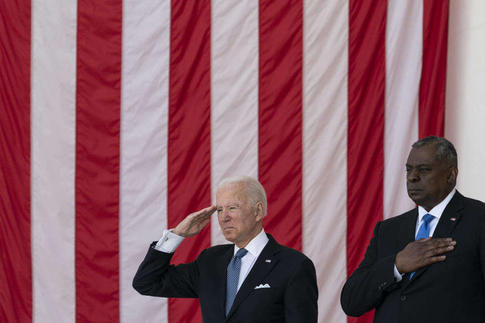 President Joe Biden salutes as Secretary of Defense Lloyd Austin places his hand over heart during the playing of "Taps," during the National Memorial Day Observance at the Memorial Amphitheater in Arlington National Cemetery, Monday, May 31, 2021, in Arlington, Va.(AP Photo/Alex Brandon)