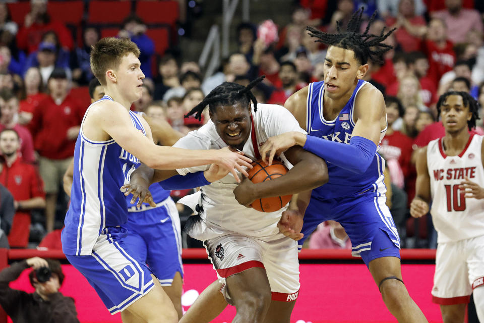 North Carolina State's D.J. Burns Jr., center, battles for the ball with Duke's Jaden Schutt, left, and Christian Reeves, right, during the second half of an NCAA college basketball game in Raleigh, N.C., Wednesday, Jan. 4, 2023. (AP Photo/Karl B DeBlaker)