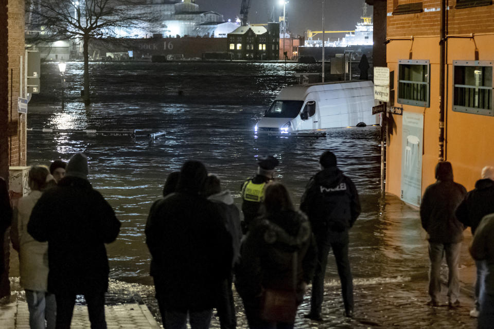 A delivery van stands in the water of the Elbe during a storm surge near the fish market in Hamburg, Germany, Thursday, Dec. 21, 2023. The Federal Maritime and Hydrographic Agency predicted a severe storm surge in Hamburg overnight due to the storm depression "Zoltan." (Bodo Marks/dpa via AP)