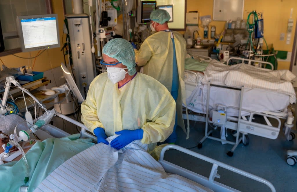 Intensive care nurses treat patients severely ill with Covid-19 disease in the intensive care unit at the University Hospital in Halle (AP)