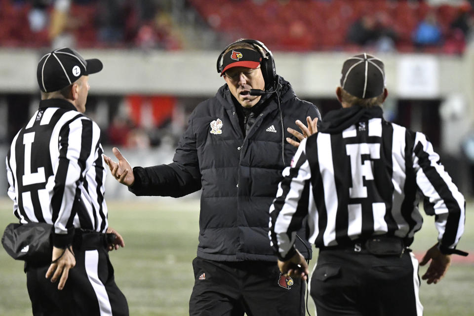 Louisville head coach Scott Satterfield, center, argues with officials during the second half of an NCAA college football game against North Carolina State in Louisville, Ky., Saturday, Nov. 19, 2022. (AP Photo/Timothy D. Easley)