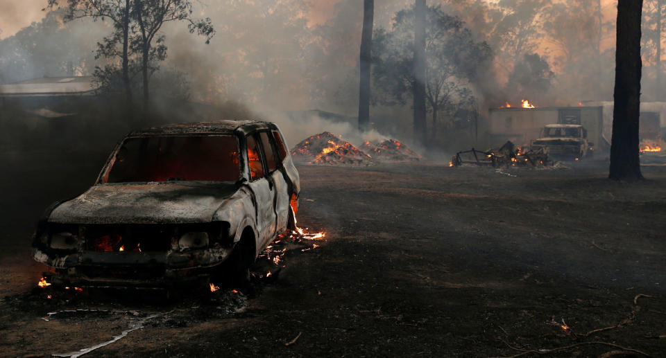 Burning property and car in Possum Brush, south of Taree in the Mid North Coast, on Tuesday.