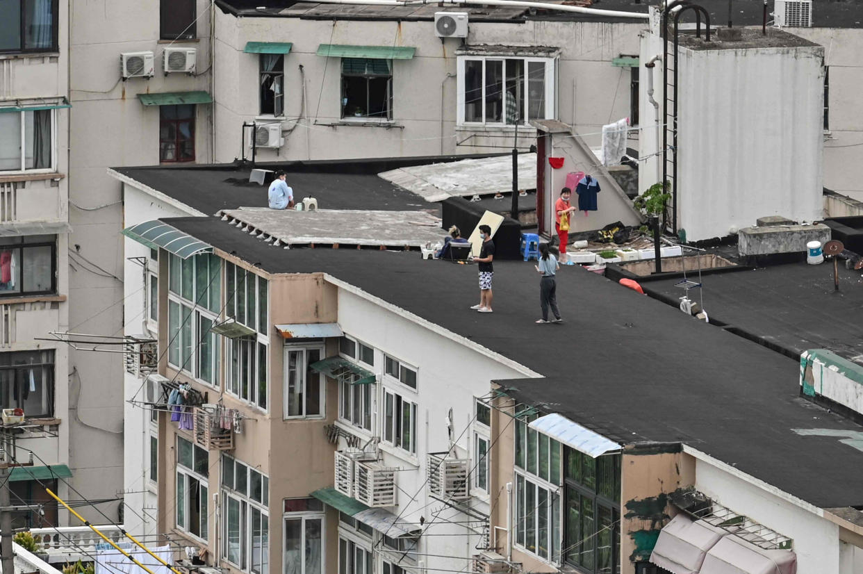 People stand on a rooftop of a building (Hector Retamal / AFP via Getty Images file)
