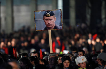 A supporter of Russian President Vladimir Putin holds his portrait in Belgrade, Serbia, January 17, 2019. REUTERS/Kacper Pempel