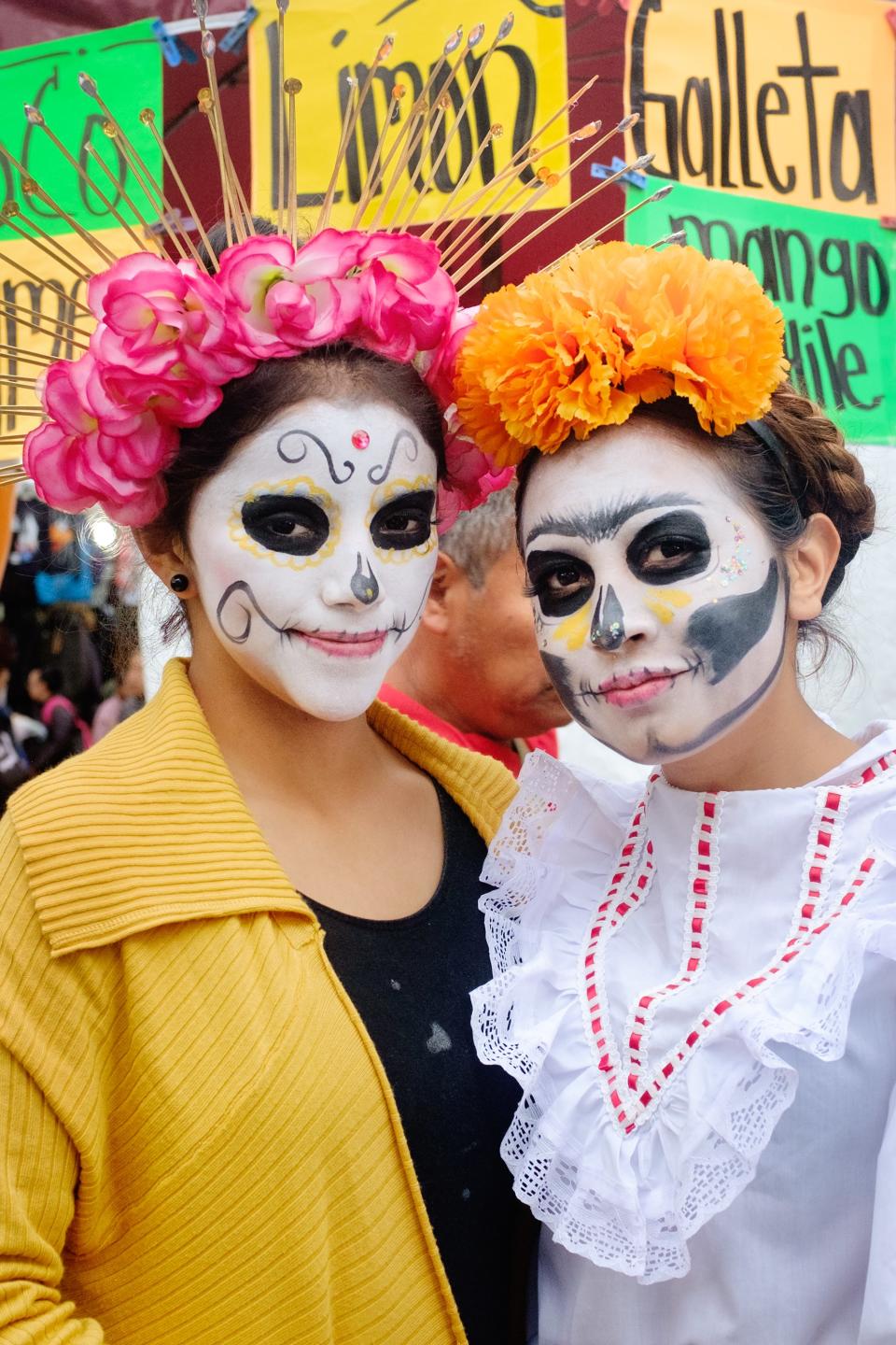 Young women from Xochimilco pose with their La Catrina face paint.