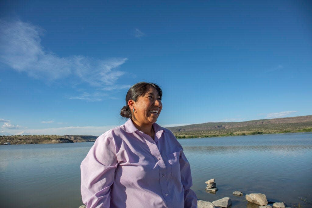 Phoebe Suina, a hydrologist and board member of the Interstate Stream Commission, stands in front of the federally built reservoir on Cochiti Pueblo.