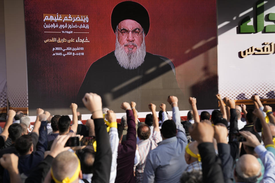 Supporters of the Iranian-backed Hezbollah group raise their fists and cheer as Hezbollah leader Sayyed Hassan Nasrallah appears via a video link, during a rally to commemorate Hezbollah fighters who were killed in South Lebanon last few weeks while fighting against the Israeli forces, in Beirut, Lebanon, Friday, Nov. 3, 2023. Nasrallah's speech had been widely anticipated throughout the region as a sign of whether the Israel-Hamas conflict would spiral into a regional war. (AP Photo/Hussein Malla)