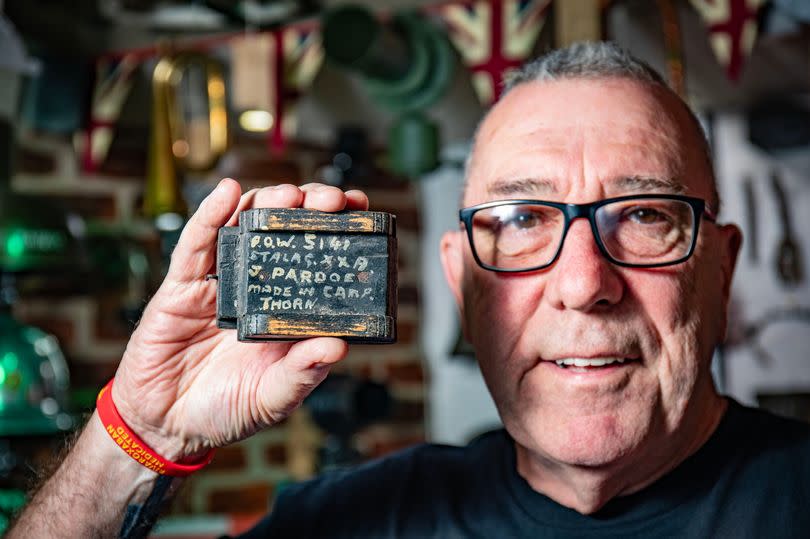 Ray with a model of a wooden tank carved by World War Two soldier James Pardoe while interned at Stalag XX-A POW camp in Toruń, German-occupied Poland. -Credit:William Lailey / SWNS