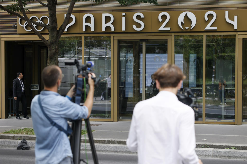 Reporters work outside the headquarters of the Paris Olympic organizers, Tuesday, June 20, 2023 in Saint-Denis, outside Paris. French investigators searched the headquarters of Paris Olympic organizers on Tuesday in a probe into suspected corruption, according to the national financial prosecutor's office. (AP Photo/Thomas Padilla)