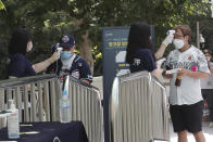 Fans wearing face masks to help protect against the spread of the new coronavirus have their temperatures checked as they arrive to watch the KBO league game between Doosan Bears and LG Twins in Seoul, South Korea, Sunday, July 27, 2020. South Korean Baseball Organization (KBO) on Sunday started admitting fans to the games but only at 10% capacity for each venue. (AP Photo/Ahn Young-joon)