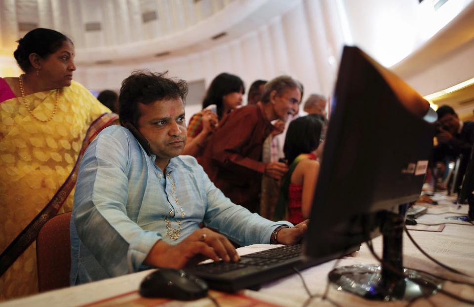 A stockbroker speaks on phone while trading at a terminal during the Diwali special trading session celebrating the annual Hindu festival of lights at the Bombay Stock Exchange (BSE) in Mumbai November 3, 2013. India's benchmark BSE share index rose to a second consecutive record high in a special trading session on Sunday, led by gains in Indian Bank, Tata Motors and ONGC on expectations of better quarterly earnings, while strong foreign flows continued to boost sentiment. REUTERS/Danish Siddiqui (INDIA - Tags: BUSINESS RELIGION)