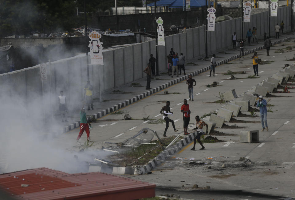 Protesters run away as police officers use teargas to disperse people demonstrating against police brutality in Lagos, Nigeria, Wednesday Oct. 21, 2020.  / Credit: Sunday Alamba / AP