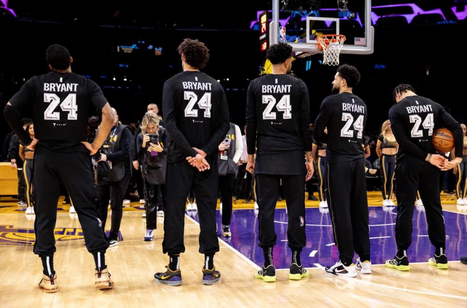 Lakers players wear black shirts with white lettering honoring Kobe Bryant during pregame warmups.