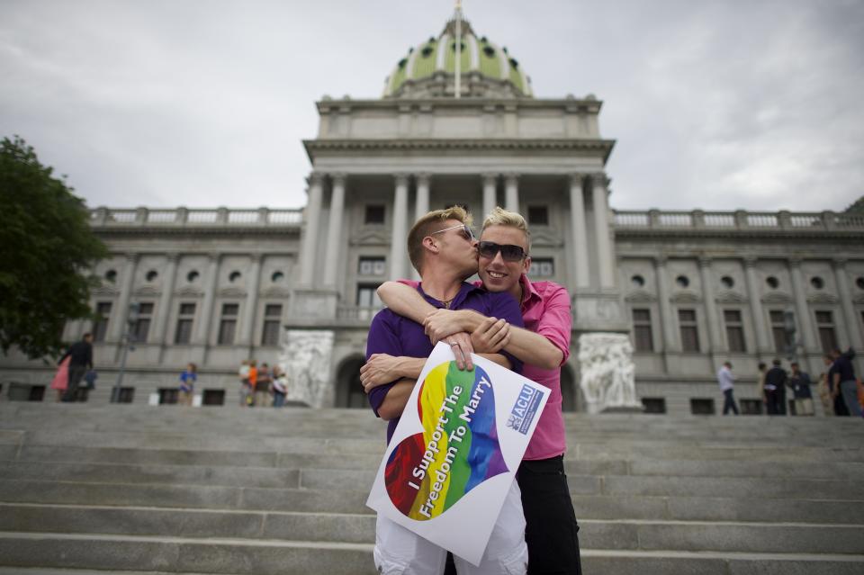 Mike Woods, 28, and Brandon Parsons, 30, embrace on the Pennsylvania State Capital steps following a rally with gay rights supporters after a ruling struck down a ban on same sex marriage in Harrisburg, Pennsylvania, May 20, 2014. (REUTERS/Mark Makela)