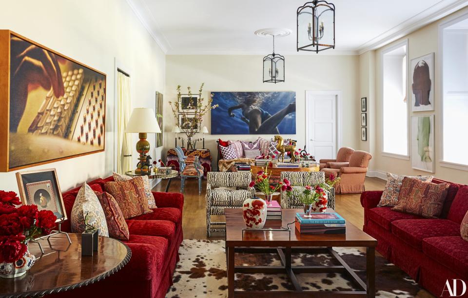 Damian Loeb artworks (left and center) hang in the living room, where matching sofas wear a Pierre Frey velvet.