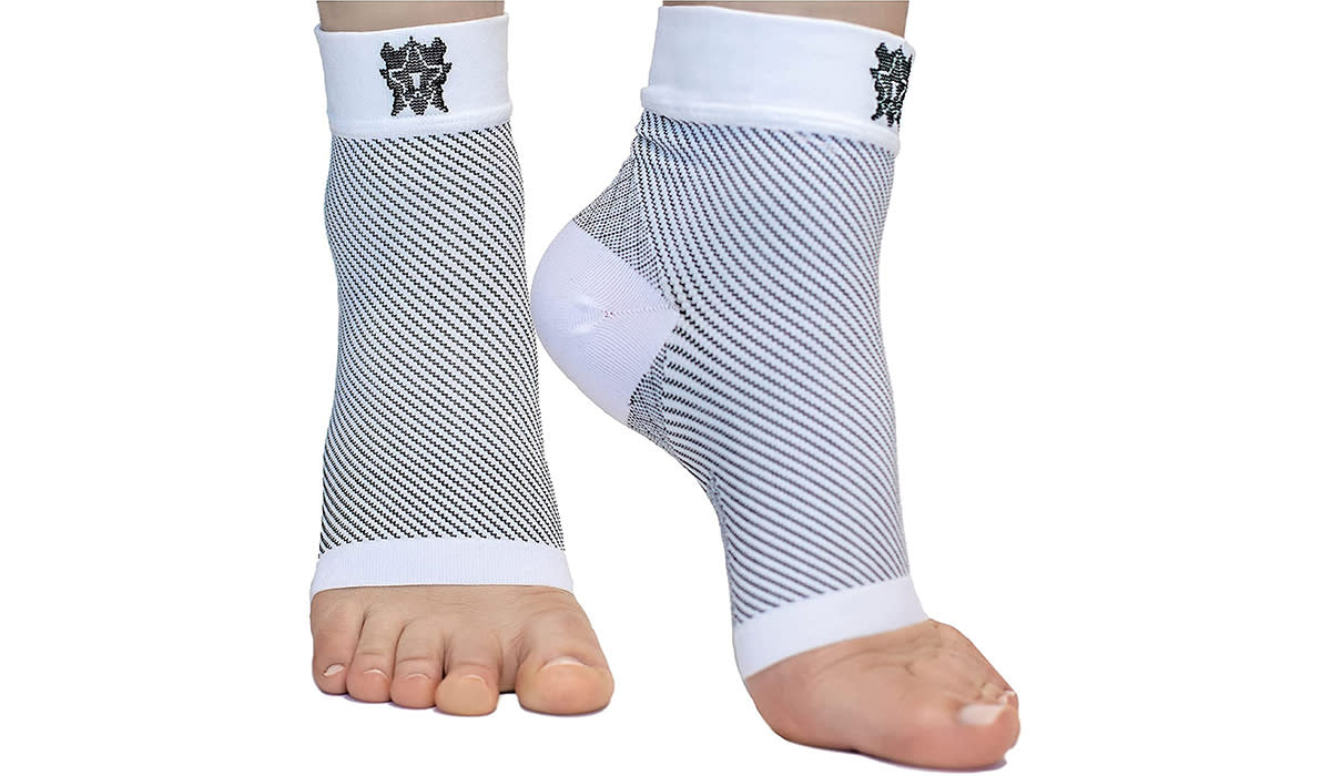 A pair of feet wearing toe-less compression socks