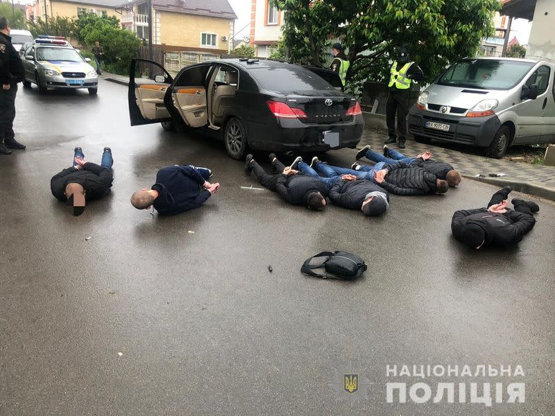 Police officers detain men suspected of taking part in a recent armed conflict in Brovary