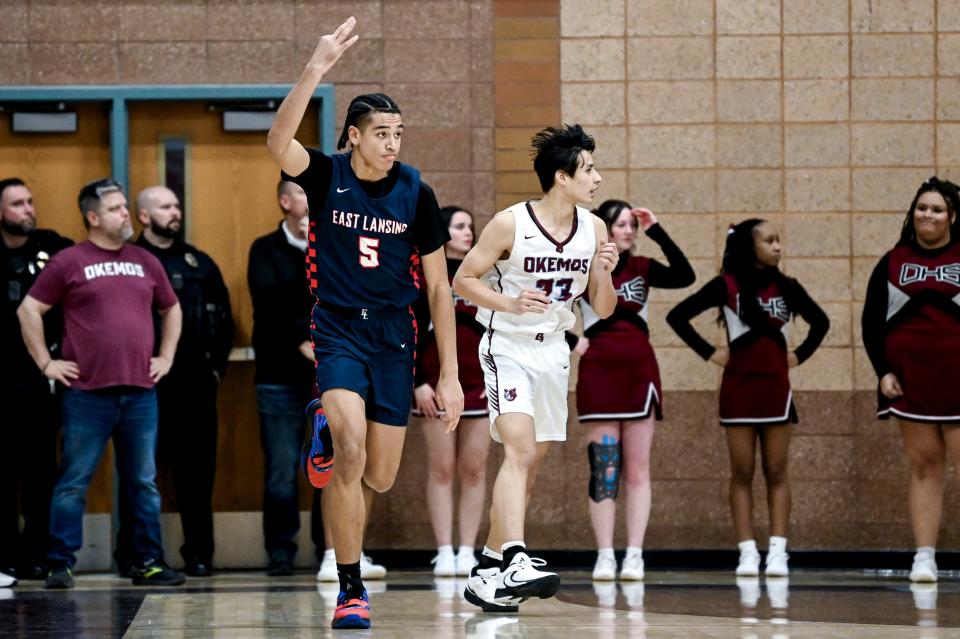 East Lansing's Cameron Hutson, left, celebrates a 3-pointer against Okemos during the first quarter on Thursday, Jan. 25, 2024, at Okemos High School.
