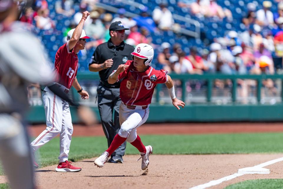Oklahoma outfielder John Spikerman (8) rounds third base to score in the the fifth inning against Texas A&M during an NCAA College World Series baseball game Wednesday, June 22, 2022, in Omaha, Neb.