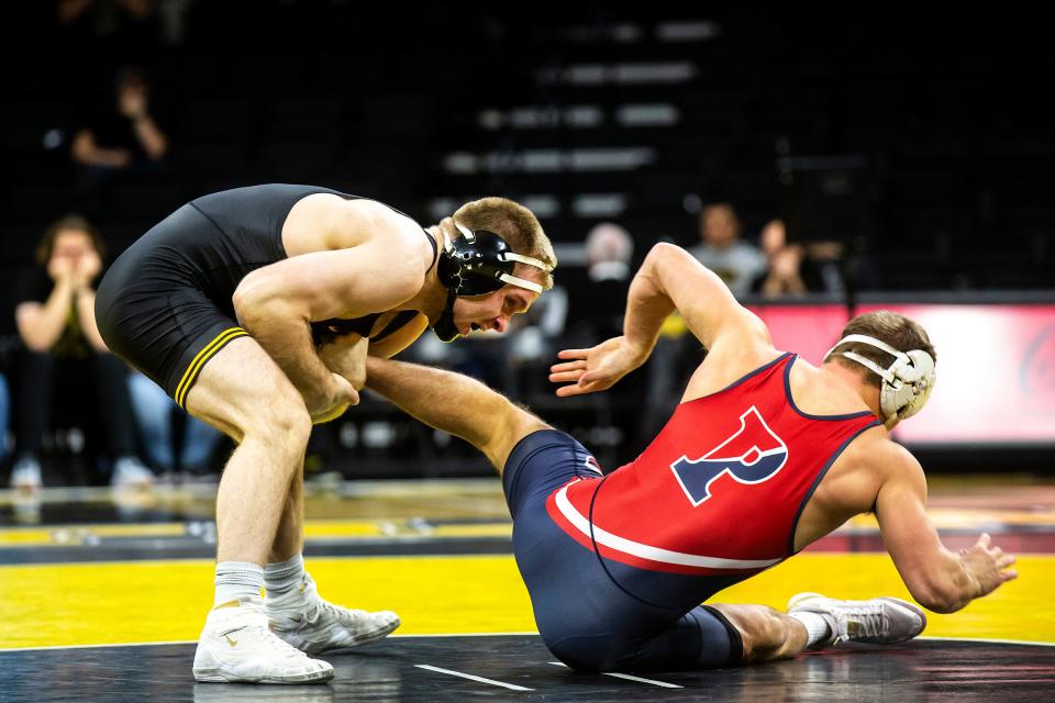 Iowa's Patrick Kennedy, left, wrestles Penn's Lucas Revano at 165 pounds during a NCAA men's wrestling dual, Saturday, Nov. 26, 2022, at Carver-Hawkeye Arena in Iowa City, Iowa.