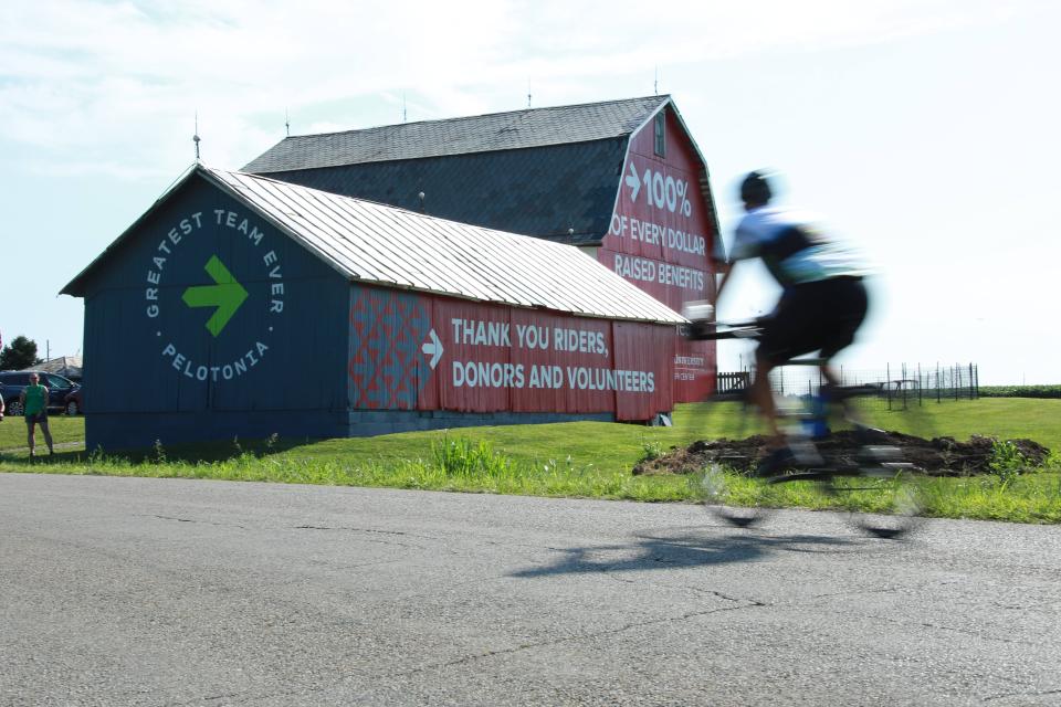 A Pelotonia rider passes a barn recently painted by "The Barn Artist" near Pickerington Ponds in 2019.